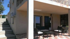 een gebouw met stoelen en een tafel op een patio bij LES TERRASSES D ACQUACITOSA in SERRA DI FIUMORBO