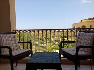 two chairs and a table in front of a balcony at Apartment Marassi in El Alamein