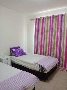 a bedroom with two beds and a window with curtains at Apartment Marassi in El Alamein