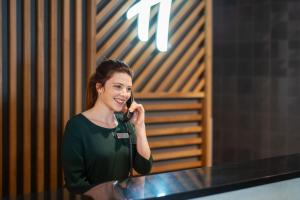 a woman is talking on a cell phone at Holiday Inn Bournemouth by IHG in Bournemouth