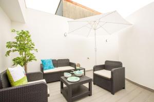 a living room with two chairs and an umbrella at Espinho Beach 4 Stays in Espinho