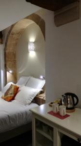 een slaapkamer met een bed en een tafel met 2 mokken bij L'antre ami in Savigny-lès-Beaune