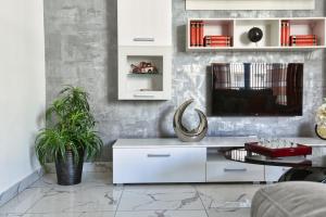 a living room with a tv and a white cabinet at A Bed Of Roses in Marsalforn