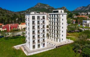 an aerial view of a white building with mountains in the background at Mariner Apartments in Sutomore