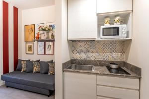 una cocina con fregadero y un sofá en una habitación en Casa Vacanze In Arte Milano, en Milán