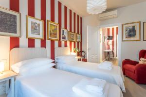 two beds in a room with red and white stripes at Casa Vacanze In Arte Milano in Milan