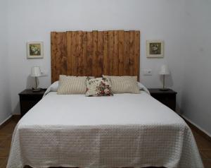 1 dormitorio con 1 cama blanca grande y 2 lámparas en El Barranquillo, en Cazalla de la Sierra
