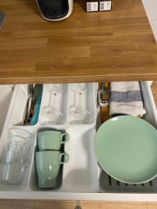uma gaveta numa cozinha com copos e pratos em City Apartment am Hauptbahnhof N3 em Nurembergue