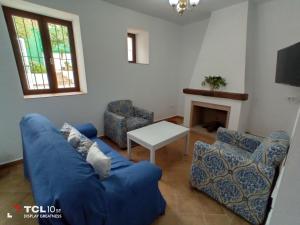 sala de estar con sofá azul y mesa en El Barranquillo, en Cazalla de la Sierra