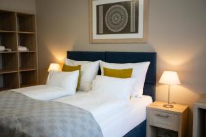 a bedroom with a bed with white sheets and yellow pillows at SALAMANDRA Hotel in Banská Štiavnica