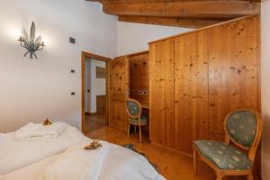 a bedroom with two beds and two chairs at Chalet Mountain Plaza - Apt Homewood in Pinzolo