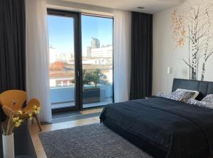 1 dormitorio con cama y ventana grande en Baltiq Plaza Apartment, en Gdynia