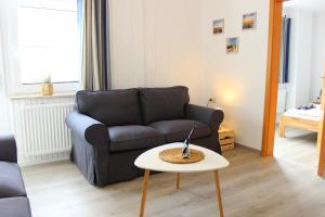 uma sala de estar com um sofá e uma mesa em Gästehaus Sulsdorf - Adults only em Sulsdorf auf Fehmarn