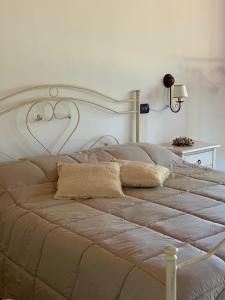 - un grand lit avec une tête de lit blanche dans une chambre dans l'établissement Barsentello, à Noci