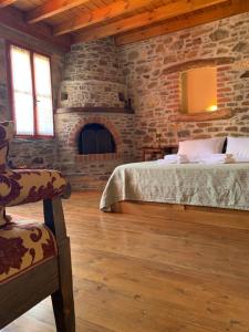 a room with two beds and a stone wall at Lithos Homes in Volissos