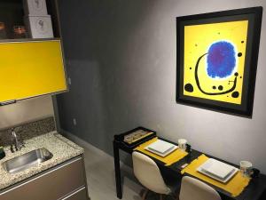 ein Zimmer mit einem Tisch mit Stühlen und einem Gemälde an der Wand in der Unterkunft Granja Viana Studio 429 decoracao industrial in Cotia + 35 Fotos