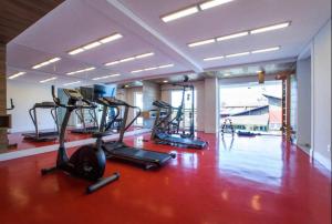 ein Fitnessstudio mit mehreren Laufbändern und Crosstrainern in einem Zimmer in der Unterkunft Granja Viana Studio 429 decoracao industrial in Cotia