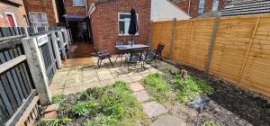 a patio with a table and chairs next to a fence at Sherwood Terrace 3 Bedroom 1 Double Bed 4 Single Beds Entire Property Contractors Welcome in Boston