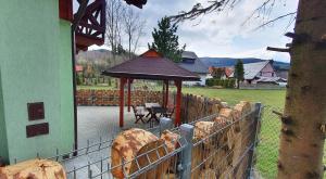 a fence with a gazebo in a yard at Zawoja Chaty Górskie D3 in Zawoja