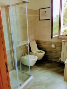 La salle de bains est pourvue de toilettes, d'un lavabo et d'une douche. dans l'établissement Villa Relax, à Stresa