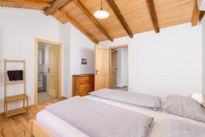 - une chambre avec un lit blanc et un plafond en bois dans l'établissement Apartment Ursula, à Lopar