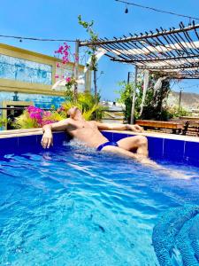 Casa La Bella Samaria Boutique في سانتا مارتا: رجل يستلقي على ظهره في مسبح