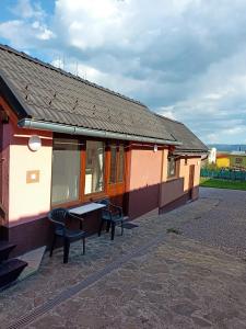 a building with two chairs and a table outside at Apartment Tomáš Jendrál in Spišský Štvrtok
