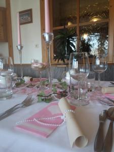 a table with a pink and white table cloth with wine glasses at Gasthof Jauk-Hartner in Sankt Johann im Saggautal