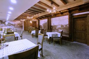 a restaurant with tables and chairs in a room at Hotel Happy in Gjakove