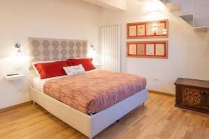 a bedroom with a large bed with red pillows at Casa Flora in Pennabilli