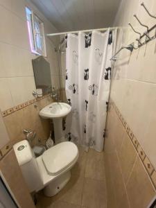 uma casa de banho com um WC e uma cortina de chuveiro em Havana em Adler