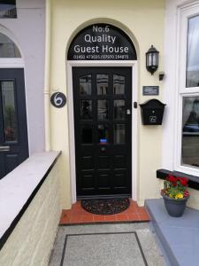 a black front door of a guest house at No 6 Quality Guesthouse in Llandudno