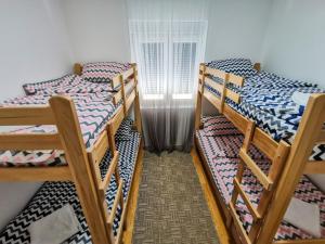 three bunk beds in a room with a window at Drinska kućica in Ljubovija +67 photos