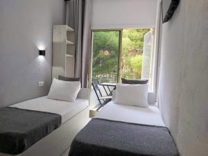 dwa łóżka w pokoju z oknem w obiekcie Casa Durán Alicante w Alicante