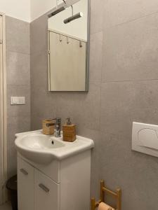 een badkamer met een witte wastafel en een spiegel bij Guesthouse Tariba in Supetarska Draga