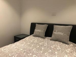 a bed with two pillows on top of it at BLOC 79/ THREE in Knokke-Heist