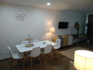 ein Esszimmer mit einem weißen Tisch und Stühlen in der Unterkunft Apartamentos Areia e Mar Norte in Vila Praia de Âncora