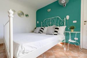 a bedroom with a white bed with a green wall at Palazzo Currò in Catania