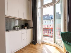 a kitchen with white cabinets and a large window at VacationClub – Wisus Apartament 19 in Świnoujście