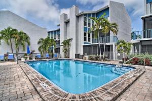 a swimming pool in front of a building at Elegant FL Condo with Pool Walk to Madeira Beach! in St Pete Beach