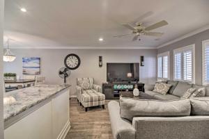 a kitchen and living room with a couch and a clock at Elegant FL Condo with Pool Walk to Madeira Beach! in St Pete Beach
