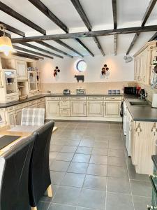 a large kitchen with white cabinets and black counter tops at Ivy Cottage in Launceston