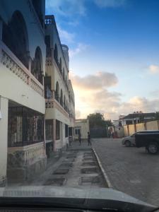 a street with a building and people walking down a street at Sea Esta suite 47 in Mombasa