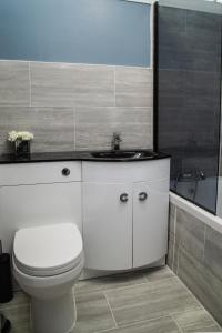 łazienka z toaletą, umywalką i wanną w obiekcie Large Modern Contractor House - FREE Parking - Staycations Welcome w mieście Northfleet