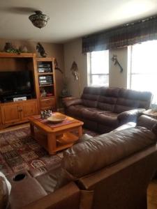 a living room with a leather couch and a coffee table at Village Lodge in Ruidoso