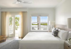 a white bedroom with a large bed and a window at Parrot Key Hotel & Villas in Key West