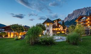 una gran casa en las montañas con un patio en Ferienwohnungen Jägerheim & Jägerhaus, en Ehrwald