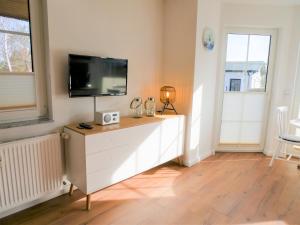 a living room with a tv on top of a dresser at Reethaus Boddenblick - Apt. 09 in Alt Reddevitz