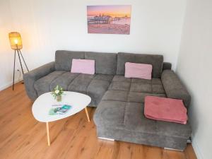 ein Wohnzimmer mit einem Sofa und einem Tisch in der Unterkunft Reethaus Boddenblick - Apt. 09 in Alt Reddevitz