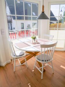 ein Esszimmer mit einem Tisch, Stühlen und einem Fenster in der Unterkunft Reethaus Boddenblick - Apt. 09 in Alt Reddevitz